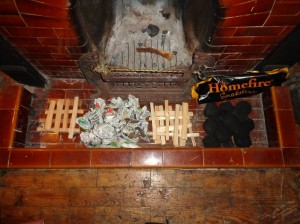 A fireplace hearth with kindling,newpaper and smokeless fuel laid out
